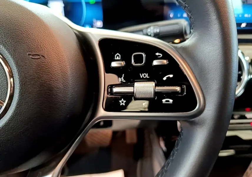 Gros plan sur le côté droit du volant cuir et alu de la Mercedes CLA 180 d Business Line 2021 avec commandes multifonctions.