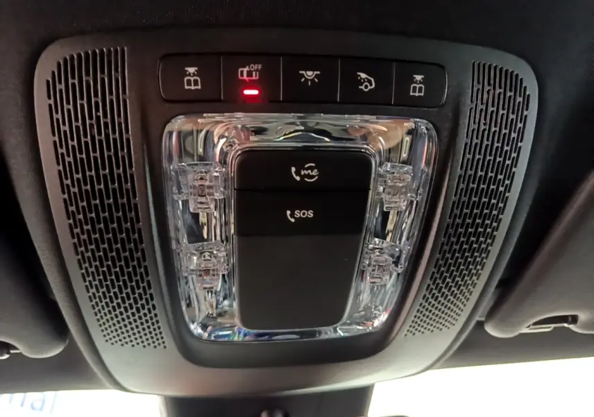 Vue en contre-plongée du plafonnier noir avec boutons SOS et appel d'urgence dans une Mercedes CLA 180 d blanche.