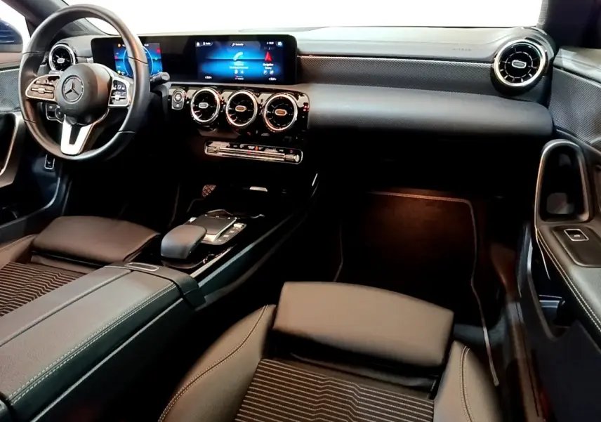 Vue intérieure avant droite de la Mercedes CLA 180 d Business Line avec tableau de bord numérique et volant cuir alu multifonctions.