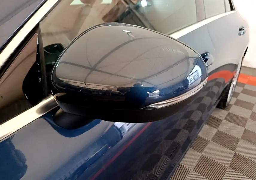 Gros plan sur le rétroviseur droit bleu foncé d’une Mercedes CLA 180 d Business Line, vue latérale partielle.