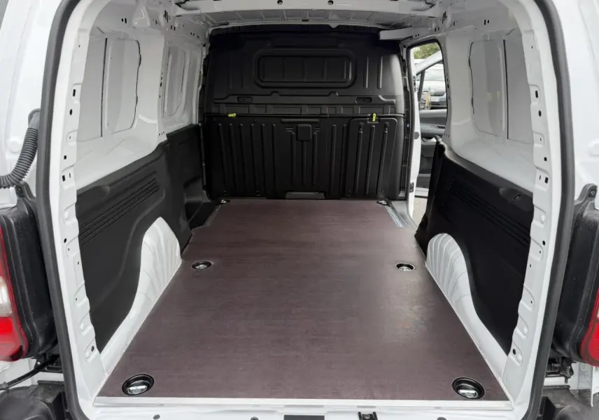 Vue arrière du Citroën Berlingo Van XL blanc Icy, montrant l’espace de chargement avec plancher bois antidérapant.
