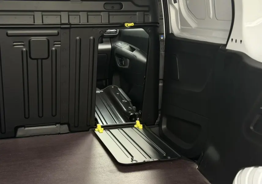 Intérieur du Citroën Berlingo Van XL blanc, vue sur le plancher bois antidérapant et cloison tôlée noire côté droit.