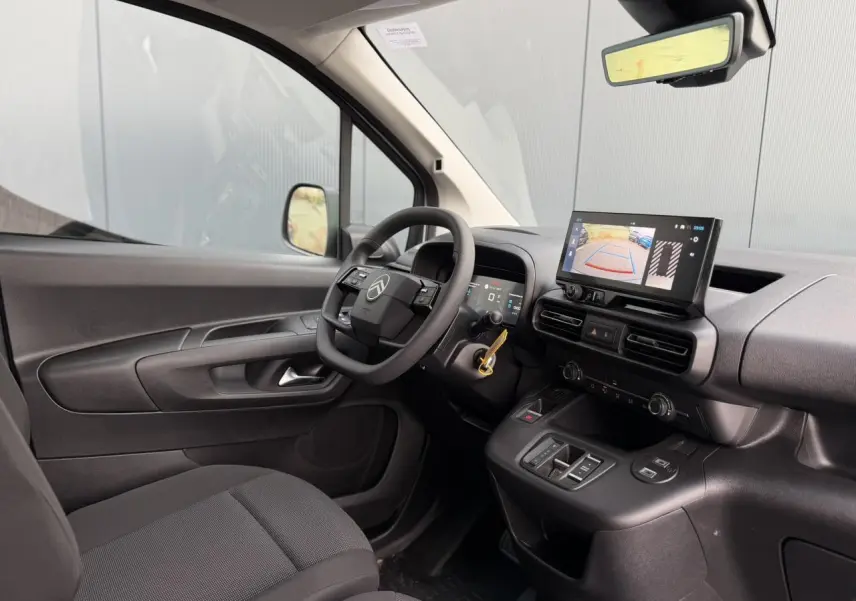 Vue intérieure côté conducteur du Citroën Berlingo blanc Icy, avec tableau de bord numérique et écran tactile de recul.