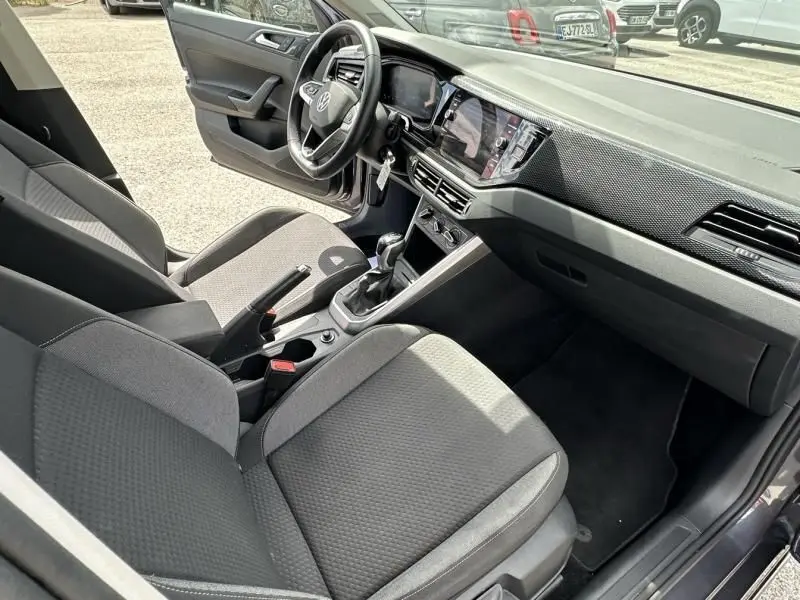 Vue intérieure côté passager de la Volkswagen Polo 1.0 TSI 95 DSG Life 2024, avec sièges gris foncé et tableau de bord moderne.