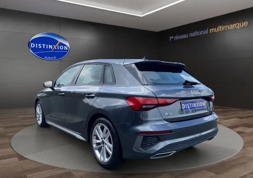 Audi A3 Sportback gris Daytona vue 3/4 arrière droit, avec jantes alliage et feux arrière LED distinctifs.