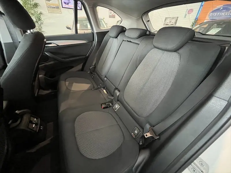 Vue intérieure arrière côté droit du BMW X1 XDRIVE 25E blanc avec sièges en tissu noir et détails gris.