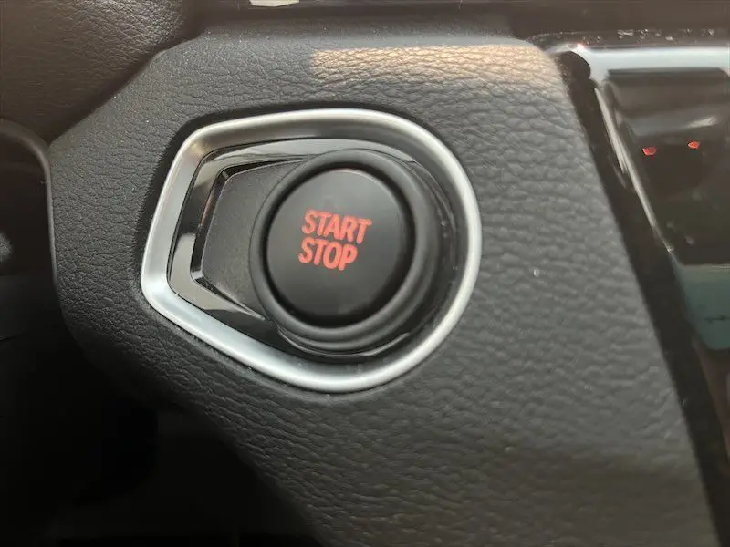 Bouton Start Stop en gros plan sur le tableau de bord noir du BMW X1 XDRIVE 25E blanc alpin 2021 hybride rechargeable.