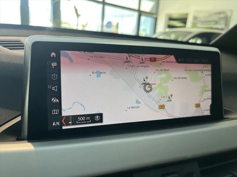 Écran de navigation intérieur du BMW X1 XDRIVE 25E blanc, affichant une carte routière avec itinéraire à 500 m.