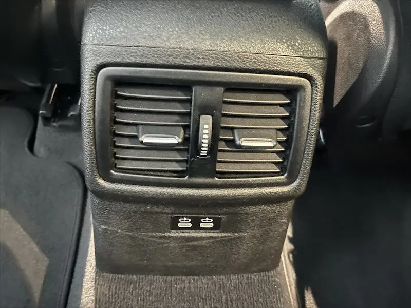 Gros plan sur les bouches d'aération arrière et ports USB du BMW X1 XDRIVE blanc alpin, intérieur noir.