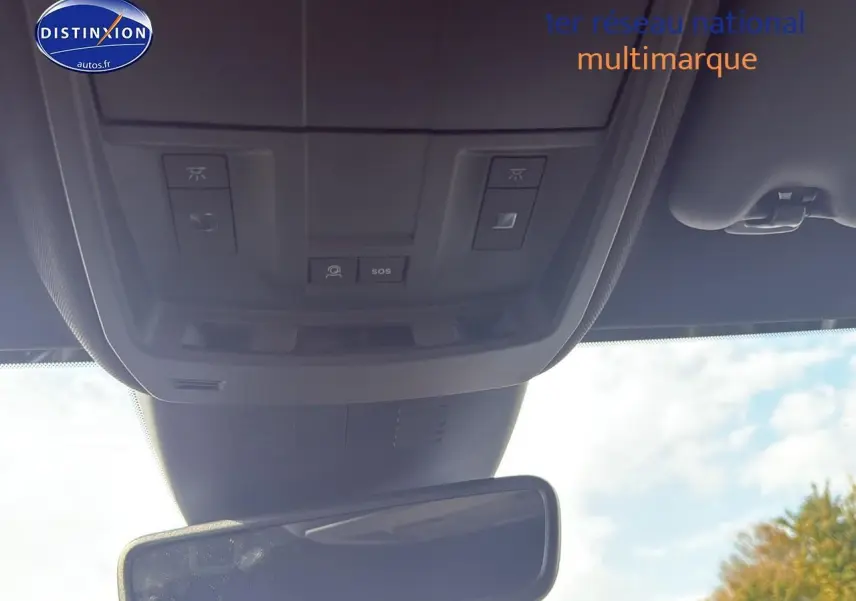 Vue intérieure du plafond avant du Peugeot 3008 gris titane, montrant les commandes d'éclairage et le bouton SOS au-dessus du rétroviseur central.