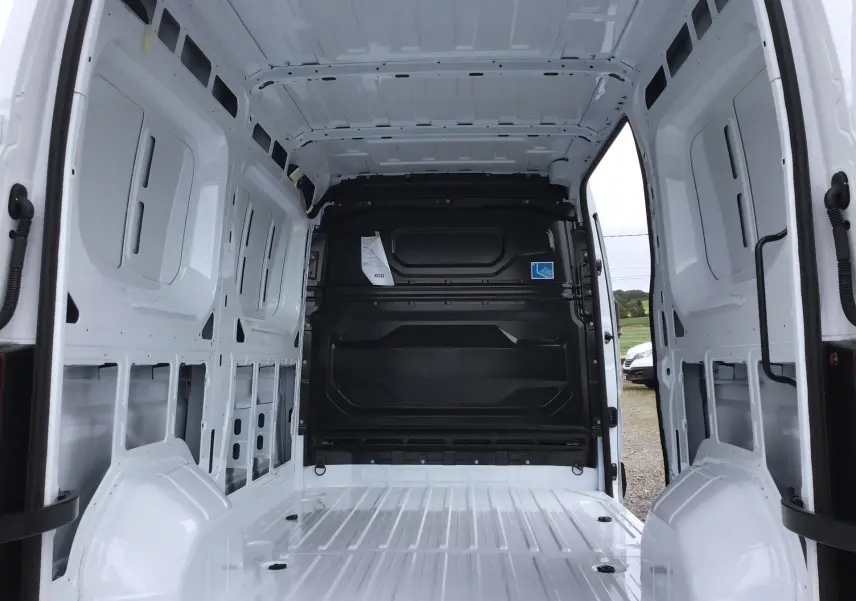 Vue intérieure arrière du Renault Master blanc L2H2 2025, montrant l'espace de chargement vide et la cloison noire séparatrice.