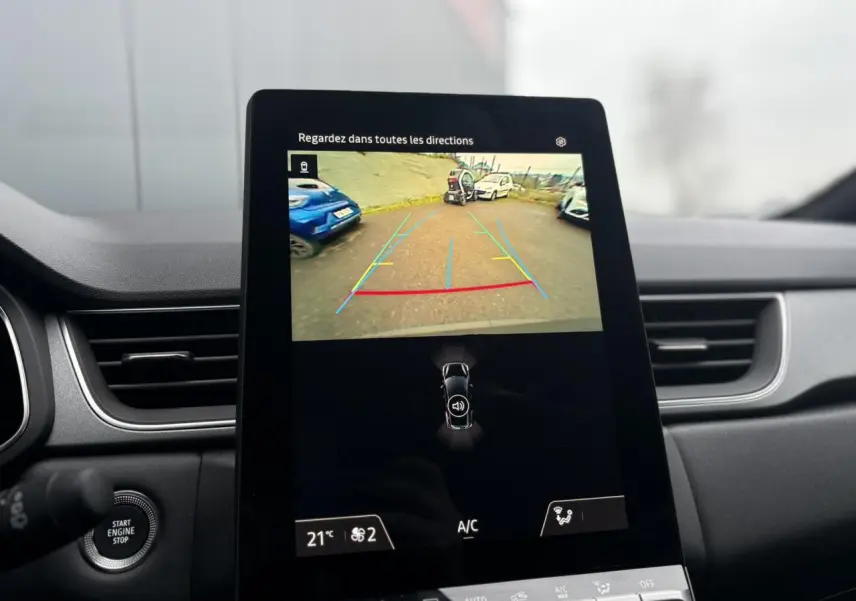 Écran central du Renault Captur 2025 affichant la caméra de recul avec vue sur un parking extérieur.