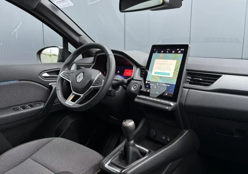 Vue intérieure côté conducteur du Renault Captur 2025 avec tableau de bord numérique et écran tactile vertical.