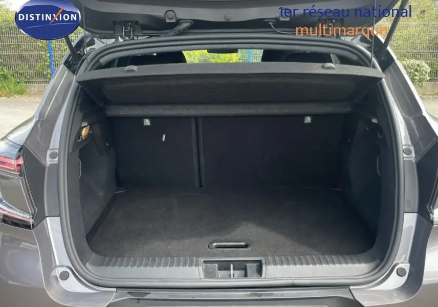 Coffre ouvert vu de l’arrière d’un Renault Captur gris Cassiopée métal avec toit noir, montrant l’espace de chargement vide.