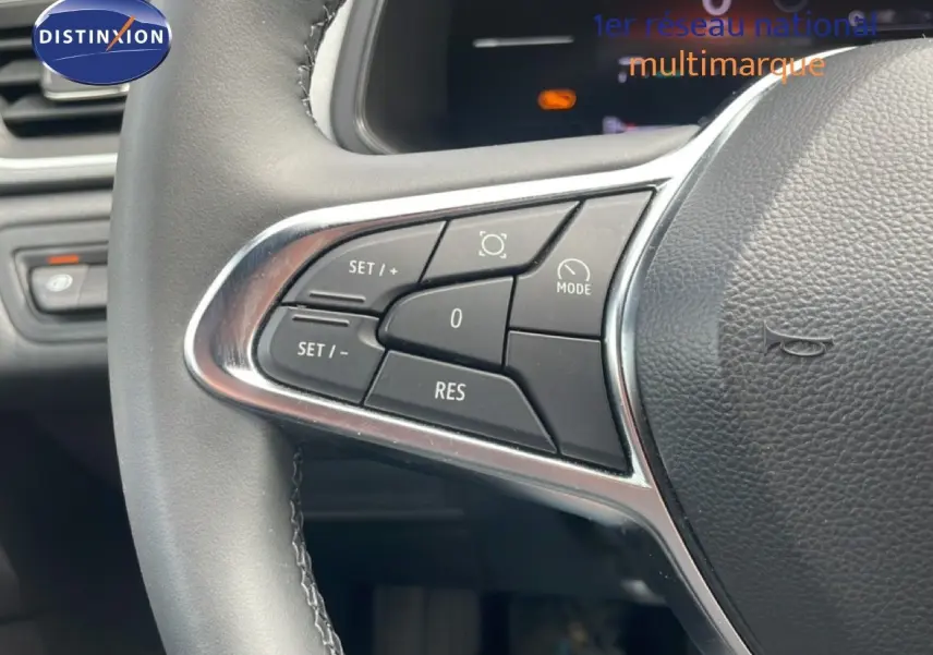 Gros plan sur les commandes au volant du Renault Captur 2025, finition gris cassiopée métal avec détails chromés.
