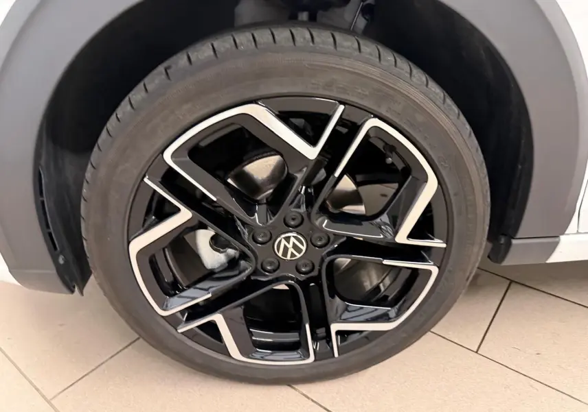 Gros plan sur la jante alliage noire et argentée du côté avant droit du Volkswagen Taigo blanc pur toit noir.