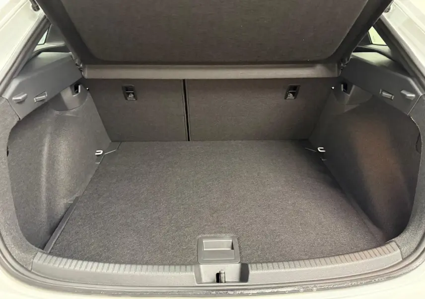Coffre ouvert du Volkswagen Taigo 2025, vue arrière, espace de chargement propre et tapis gris foncé.