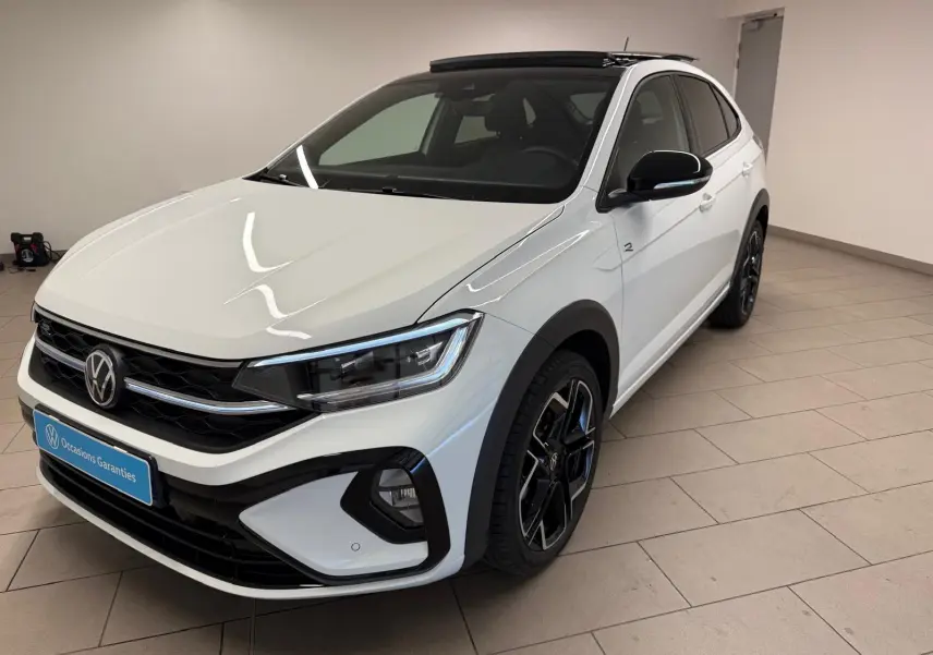 Volkswagen Taigo blanc pur toit noir en vue 3/4 avant droit, avec jantes alliage noires et calandre R-Line.