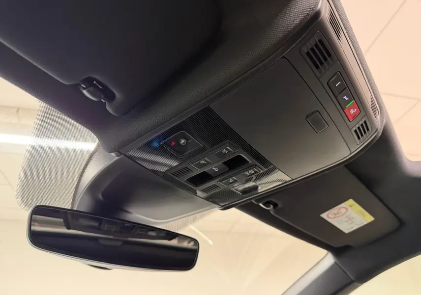 Vue intérieure du toit ouvrant et du plafonnier noir avec rétroviseur intérieur du Volkswagen Taigo blanc toit noir.