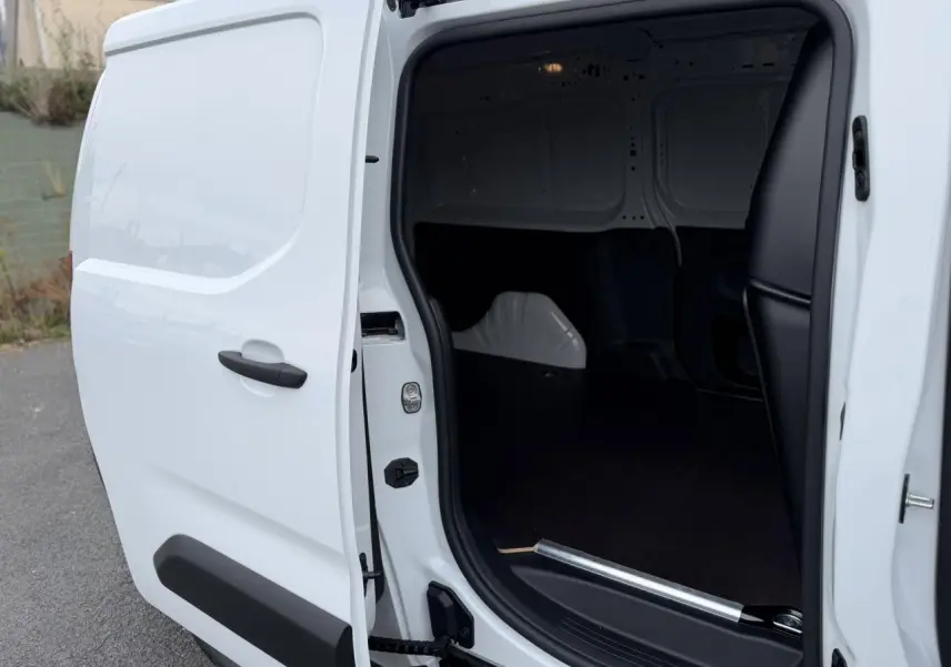 Vue côté droit du Citroën Berlingo Van XL blanc Icy avec porte latérale ouverte et plancher bois visible.