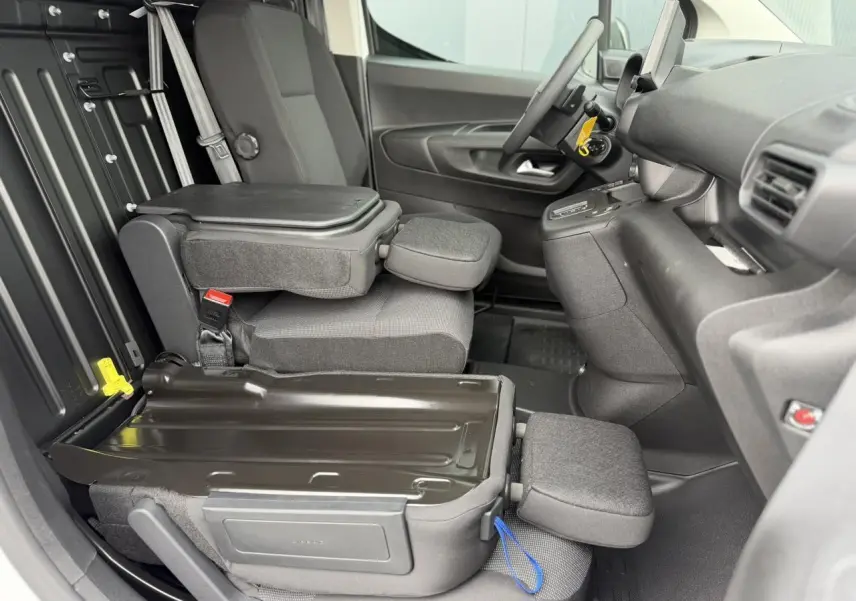 Intérieur côté conducteur du Citroën Berlingo Van XL 2026, sièges rabattus avec plancher bois visible en arrière-plan.