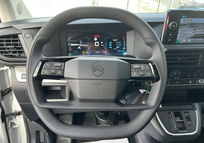 Vue intérieure centrée sur le volant du Citroën Jumpy Fourgon blanc 2025, avec tableau de bord numérique et écran tactile.
