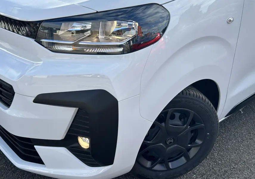 Gros plan sur l'avant droit blanc du Citroën Jumpy Fourgon 2025, mettant en valeur le phare et la roue noire.