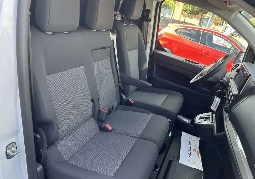 Intérieur du Citroën Jumpy Fourgon blanc 2025, vue côté droit sur sièges tissu gris et tableau de bord moderne.