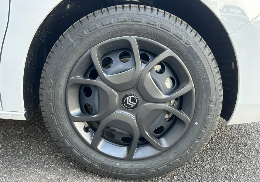 Gros plan sur la roue avant gauche du Citroën Jumpy Fourgon blanc, avec jante en alliage gris foncé au design moderne.