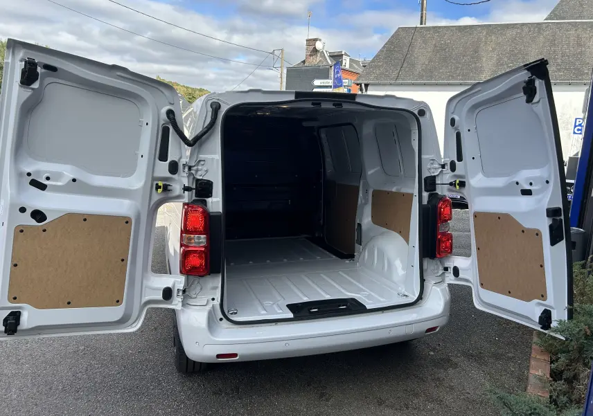 Vue arrière ouverte du Citroën Jumpy Fourgon blanc 2025, montrant l'espace de chargement vide et les portes battantes ouvertes.