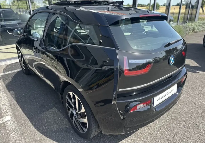 Vue 3/4 arrière droite d'une BMW i3 noire 2022 avec feux LED distinctifs et jantes alliage modernes.