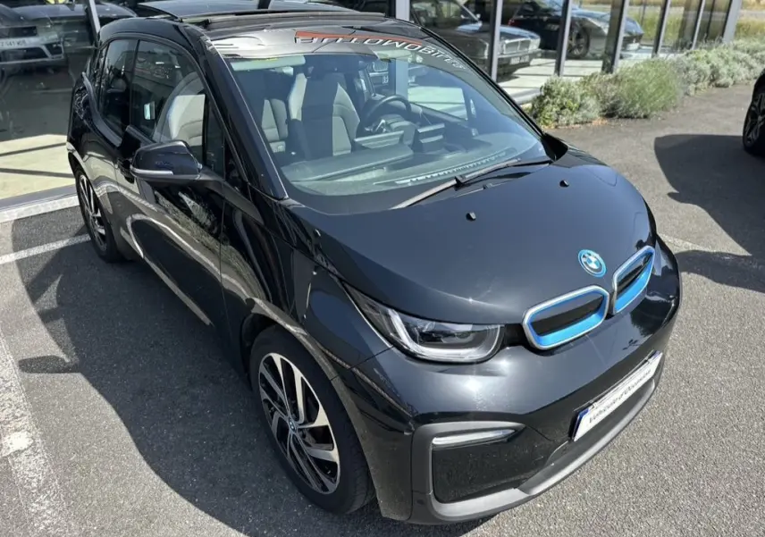 Vue 3/4 avant droite d'une BMW i3 noire électrique 2022 avec calandre bleue distinctive et jantes stylisées.