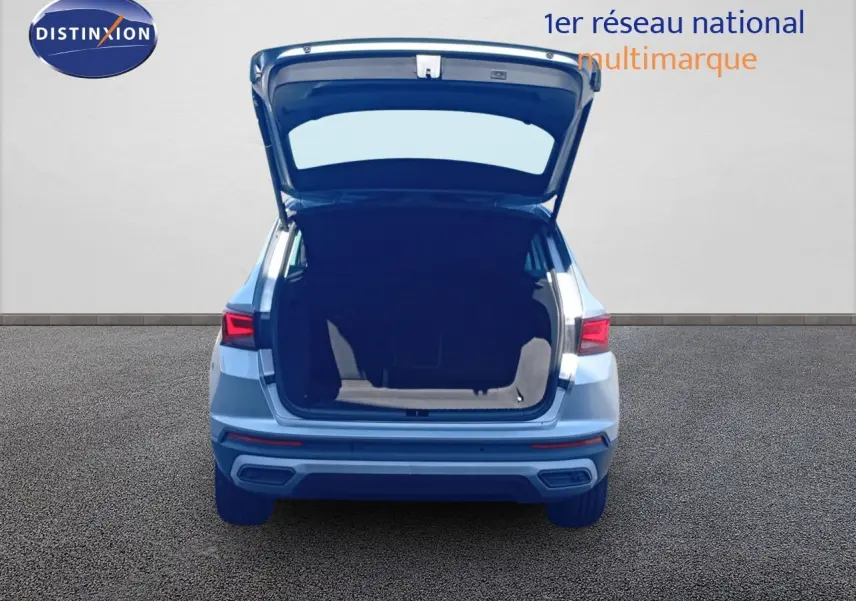 Vue arrière d'un SEAT Ateca argent Reflex Metal 2023 avec coffre ouvert montrant l'espace de chargement.