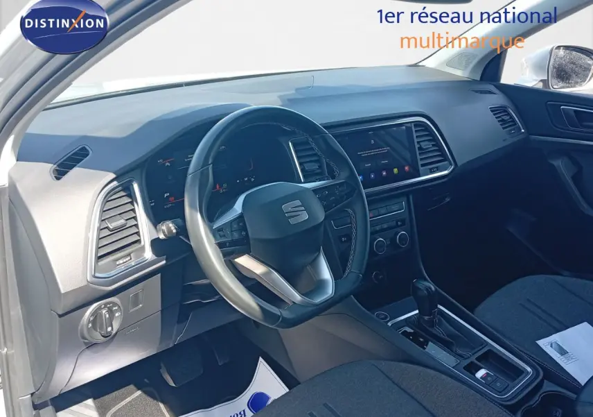 Intérieur du SEAT Ateca 2023 vu côté conducteur, tableau de bord noir avec écran tactile et volant multifonction.