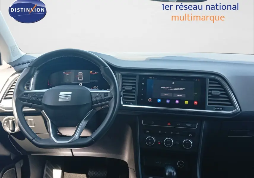 Vue frontale de l'habitacle du SEAT Ateca 2023, tableau de bord noir avec écran tactile et volant multifonction.