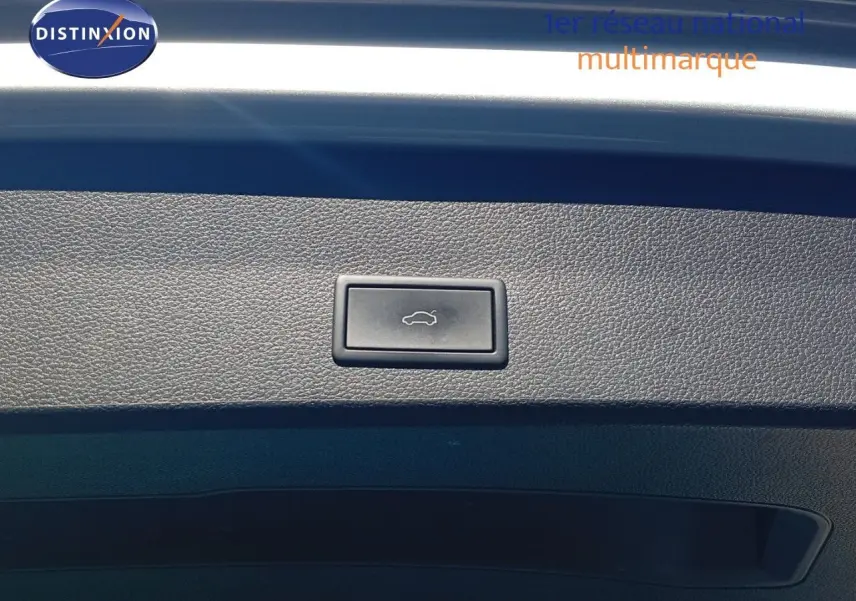 Bouton d'ouverture du coffre sur la garniture intérieure du hayon d'un SEAT Ateca argent 2023.