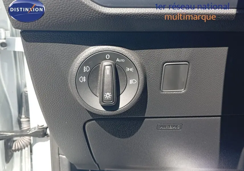 Gros plan sur le bouton de commande des phares à gauche du tableau de bord du SEAT Ateca argent 2023.