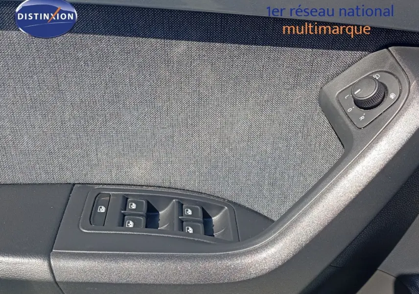 Gros plan sur la commande des vitres et réglages des rétroviseurs côté conducteur du SEAT Ateca gris intérieur tissu.