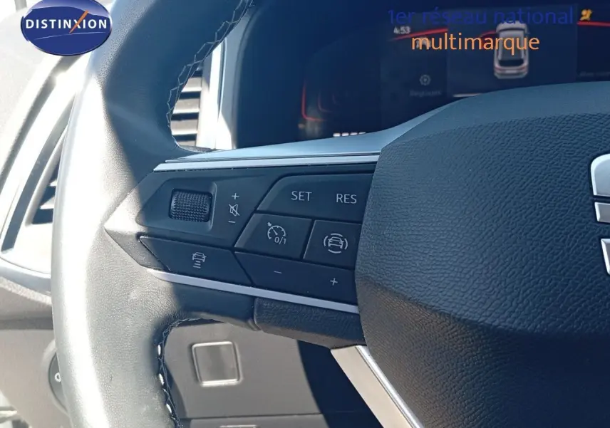 Gros plan sur le volant cuir noir du SEAT Ateca 2023 avec commandes intégrées et tableau de bord digital en arrière-plan.