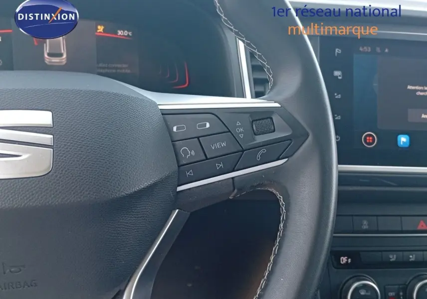 Gros plan sur le volant multifonction du SEAT Ateca 2023 avec commandes intégrées et tableau de bord numérique visible.