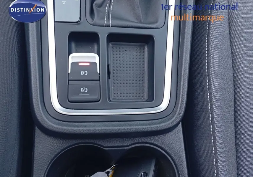 Vue rapprochée de la console centrale du SEAT Ateca 2023 argent, avec commandes électroniques et porte-gobelets.