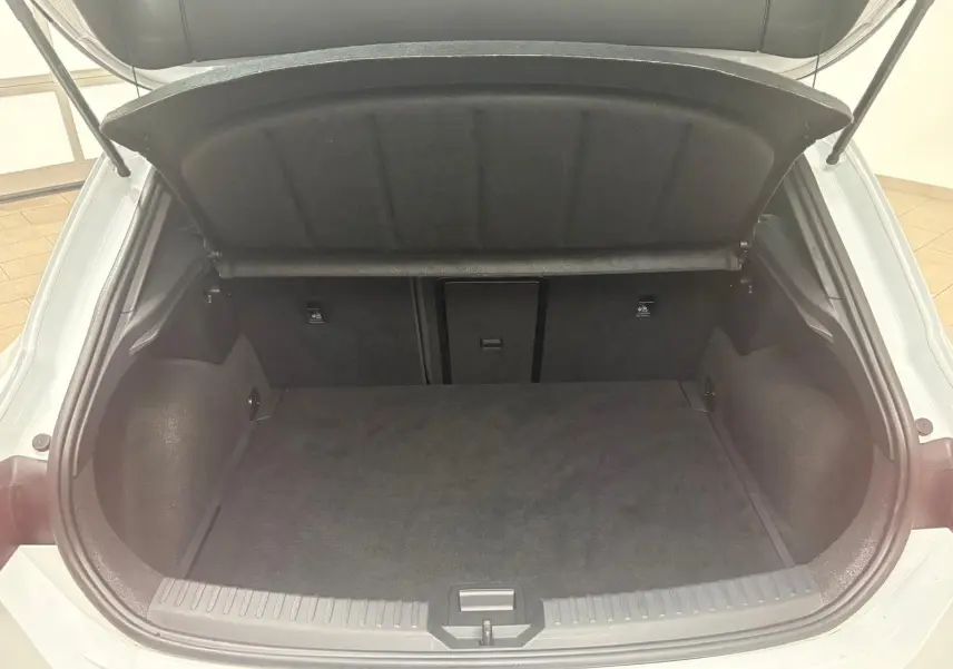 Coffre ouvert vu de l'arrière d'une CUPRA Leon blanc Nevada, montrant l'espace de chargement vide et la trappe arrière.