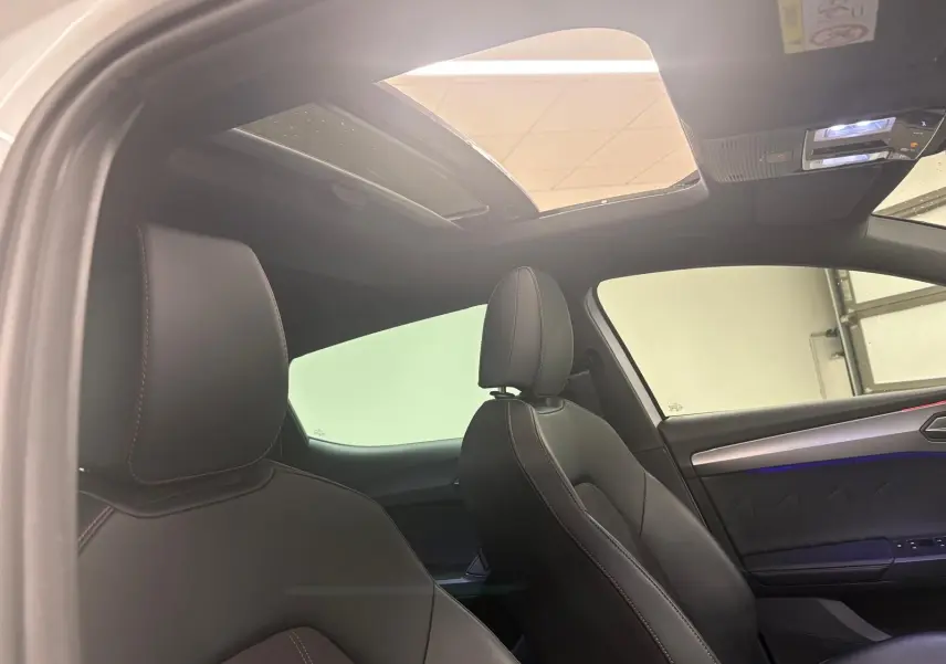 Vue intérieure côté droit montrant les sièges en cuir noir et le toit ouvrant panoramique de la CUPRA Leon 2024.