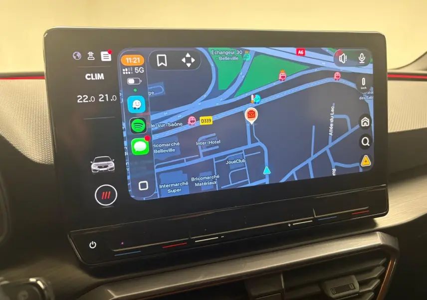 Écran tactile central affichant la navigation et applications dans l'habitacle d'une CUPRA Leon 2024 blanche.