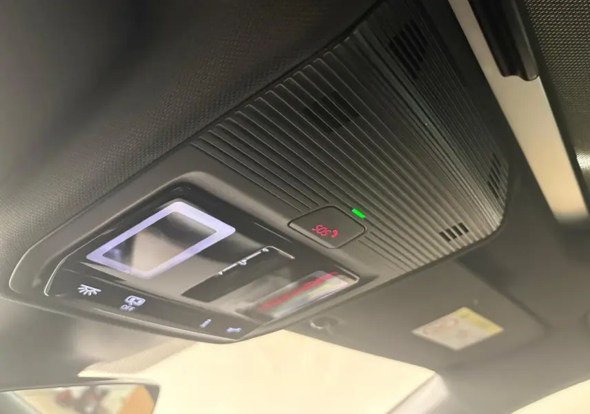 Vue en gros plan du panneau de commandes du toit ouvrant et de l'alerte SOS à l'intérieur d'une CUPRA Leon blanc Nevada 2024.