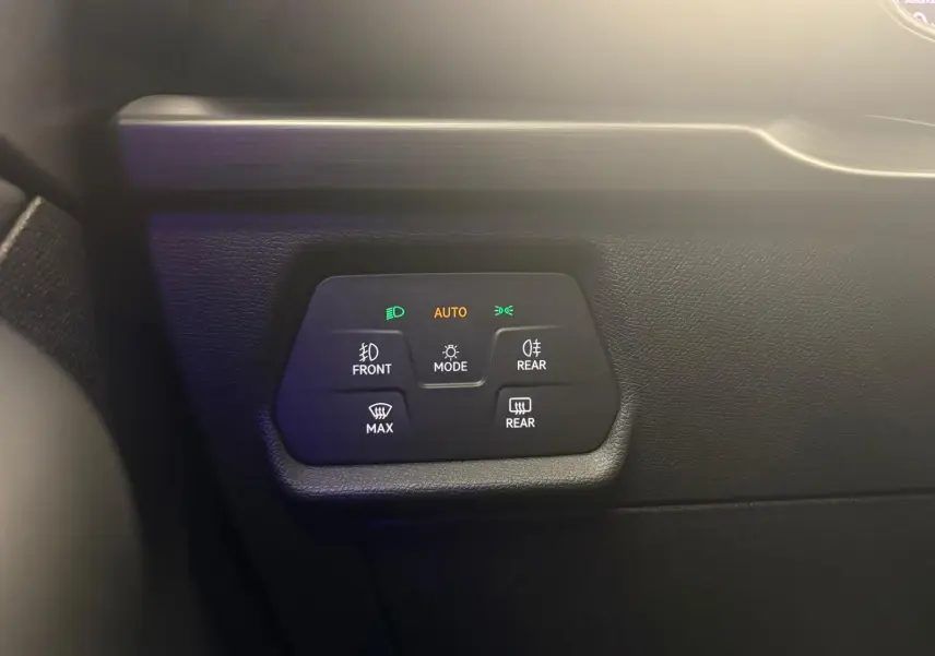 Gros plan sur les commandes d’éclairage automatiques du tableau de bord d’une CUPRA Leon blanche.