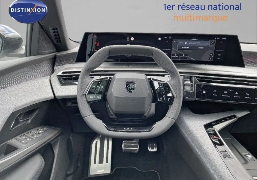 Vue intérieure centrée sur le volant GT du Peugeot 5008 Hybrid blanc Okenite avec tableau de bord numérique et finitions modernes.