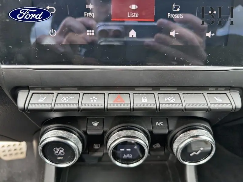 Panneau de commandes climatisation et sécurité intérieur d'une Renault Arkana gris métallisé, vue frontale rapprochée.