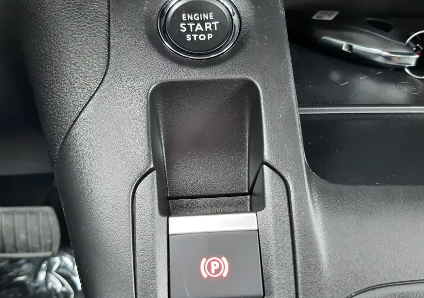 Gros plan sur la console centrale du Peugeot Rifter bleu Kiama 2026, montrant le bouton Start/Stop et le frein à main électronique.