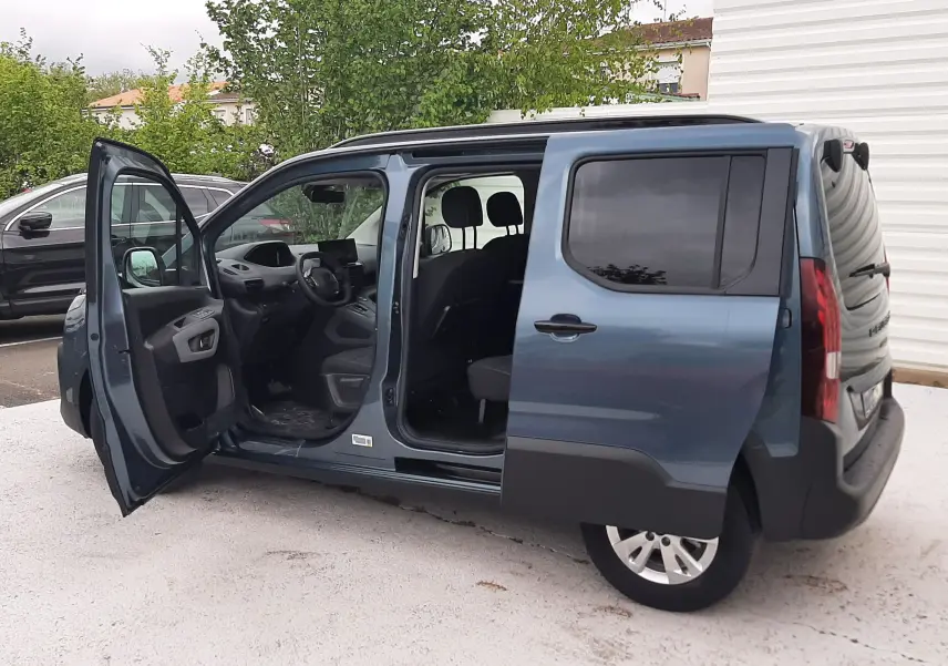Peugeot Rifter Bleu Kiama vue côté gauche 3/4 arrière avec portes avant et coulissante ouvertes, intérieur visible.